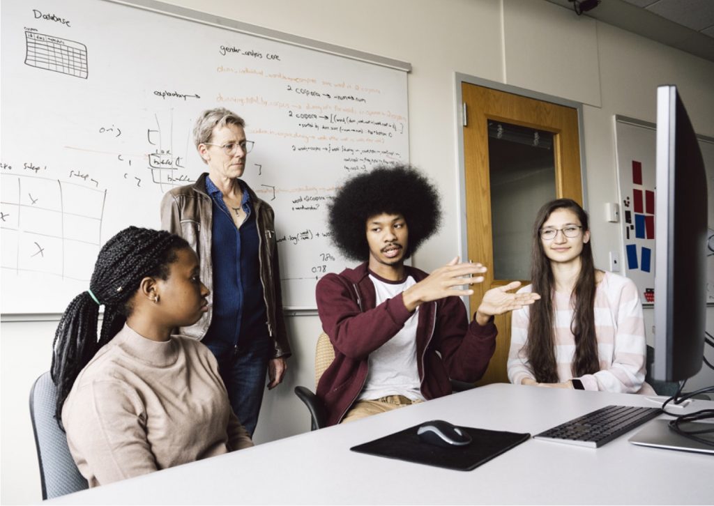 Prof. Kate Brown (standing) with UROP students Nisha Nkya, Quincy Johnson, and Kateryna Morhun (left to right). Photo: Ben Gebo