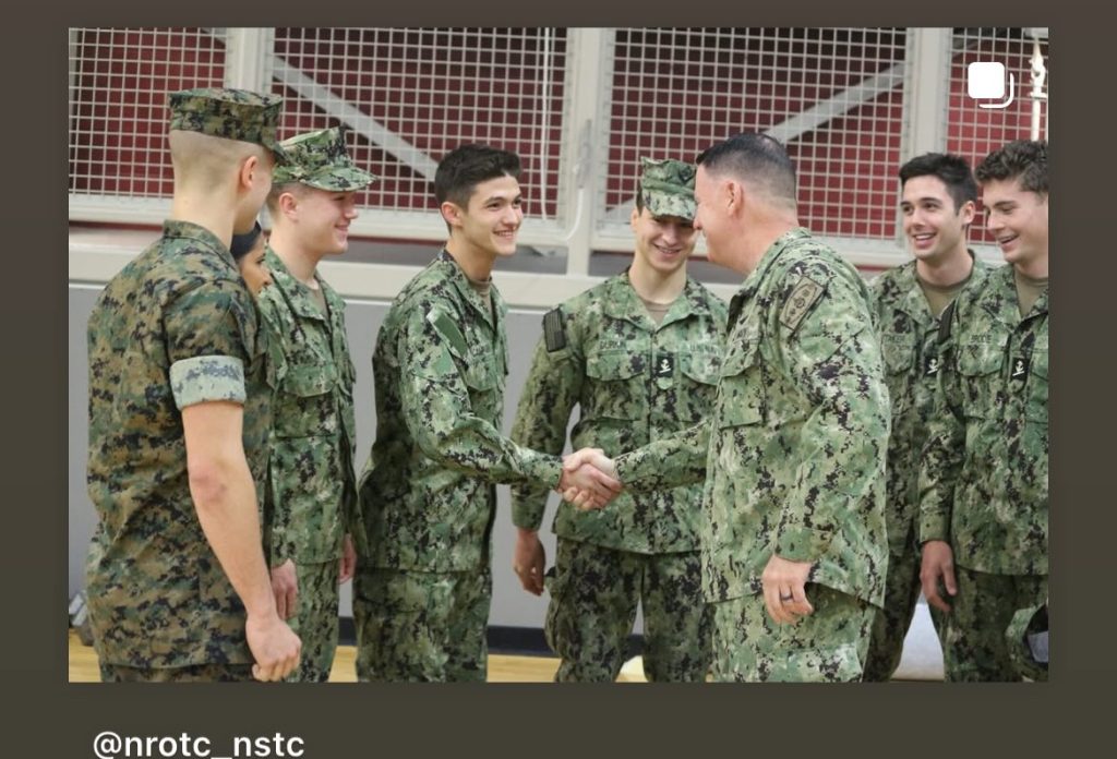 Rear Admiral Pottenburgh shakes hands with midshipmen.